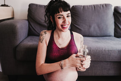 Portrait of pregnant woman exercising while sitting at home