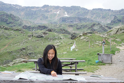 Portrait of young woman looking at a map in front of her