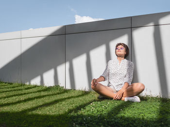 Portrait of young woman sitting on grassy field