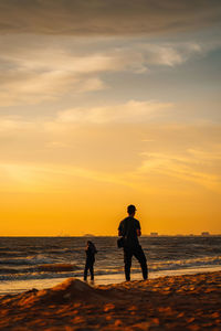 People at the beach during golden sunset.