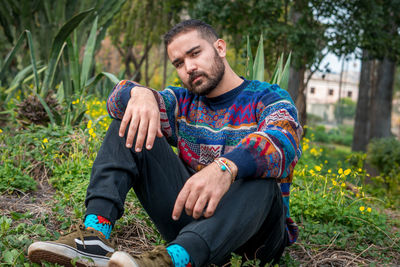 Caucasian model sitting on the ground in a public park