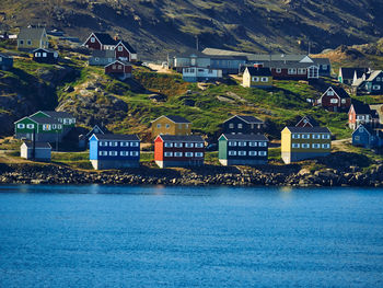 Buildings by sea against mountain