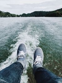 Low section of man standing in sea