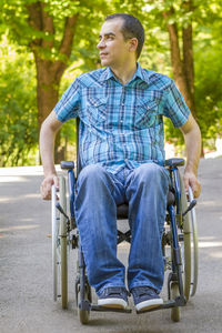 Physically disabled man looking away while sitting on wheelchair