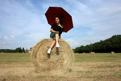 Woman standing on field against sky