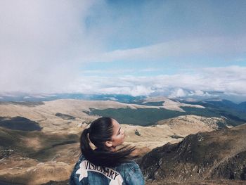 Woman standing on mountain against sky