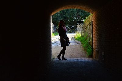 Woman standing in tunnel at park