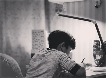 Side view portrait of boy sitting at home