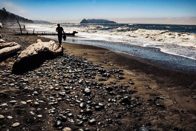 Man standing on beach against sky