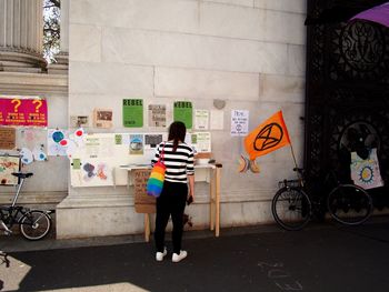 Rear view of man standing by graffiti on wall