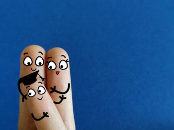 Close-up of human hand against blue wall