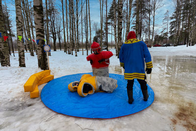 Rear view of people on snow covered land