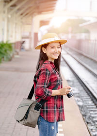 Portrait of woman standing on railroad station platform