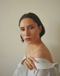 Portrait of a young woman against wall