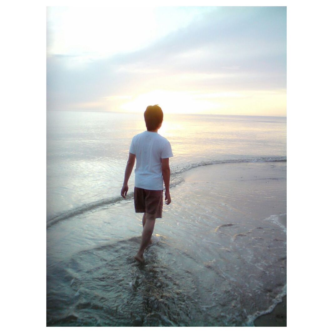 full length, sea, rear view, beach, transfer print, water, horizon over water, childhood, lifestyles, leisure activity, sky, standing, auto post production filter, shore, walking, boys, tranquility, tranquil scene