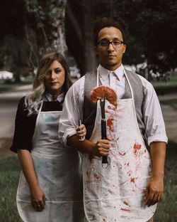 Young couple standing against trees