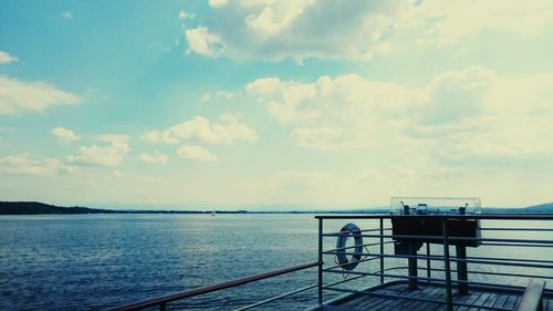 Pier by river against sky