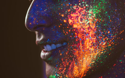 Close-up of man with multi colored face paint