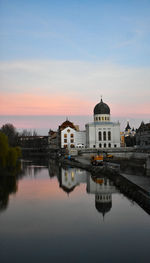 Reflection of buildings in lake at sunset