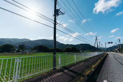 Electricity pylon by mountains against sky