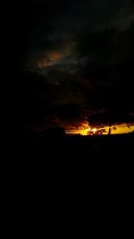 Silhouette landscape against cloudy sky during sunset