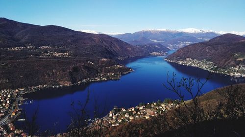 Scenic view of lake and mountains against blue sky