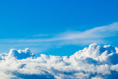 White fluffy cumulus clouds against a clear blue sky. a symbol of dreams and freedom. 