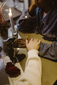 High angle view of multiracial couple holding hands during candlelight date at bar