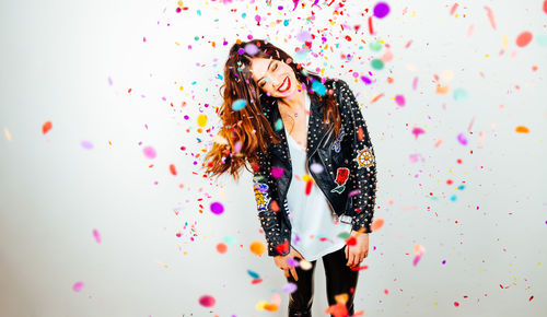 Woman standing against multi colored background