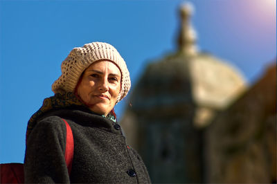 Portrait of young woman standing against sky