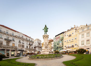 Statue in city against clear sky