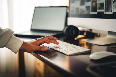 Cropped hand using laptop on table