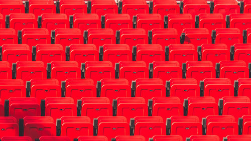 Full frame shot of empty red chairs at stadium