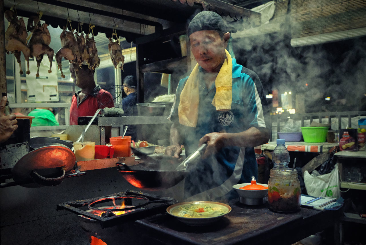 smoke - physical structure, food, preparing food, preparation, food and drink, heat - temperature, steam, stove, chef, real people, one person, wok, men, kitchen, indoors, occupation, freshness, healthy eating, night, working, one man only, adult, people, only men