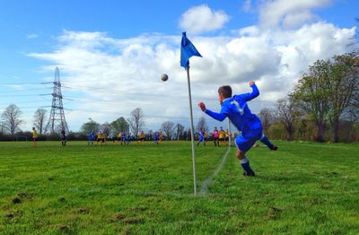 People playing soccer on grassy field