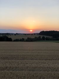 Scenic view of field against sky during sunset