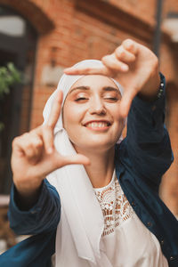 Portrait of young woman gesturing outdoors