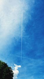 Low angle view of vapor trail against blue sky