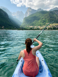 Rear view of woman on boat in mountains