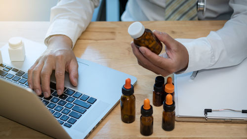 Midsection of man using laptop on table