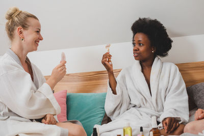 Smiling friends using digital tablet while sitting at home