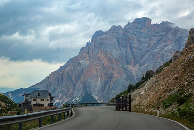 Road by mountains against sky