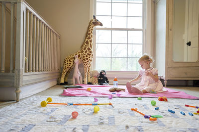 A little girl plays in her room alone