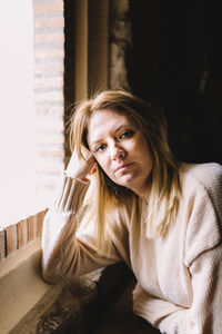 Portrait of beautiful young woman sitting at home