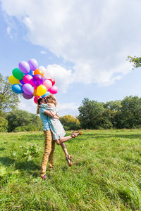 Full length of boy standing on field against sky