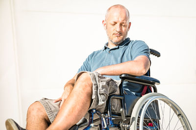 Midsection of man sitting in park