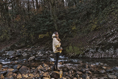 Woman standing on rock in forest