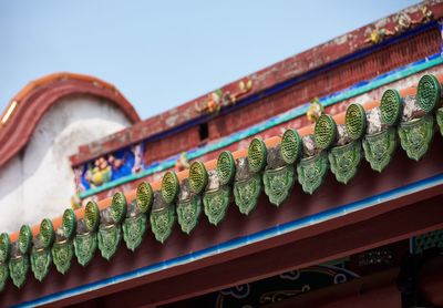 Low angle view of multi colored roof tiles against building