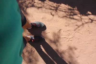 Low section of man standing on sand