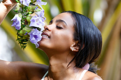 Beautiful woman smelling orchids outdoors